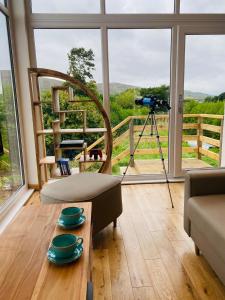 a living room with a camera and a table with dishes at Luxury Portree Cottage Hillside in Portree