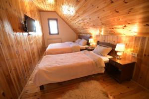 にあるApartmani pod Durmitoromの木製の壁の部屋にベッドが2つある