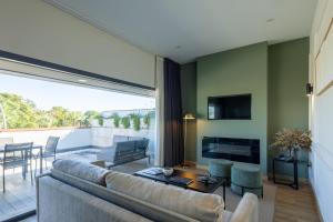 a living room with a couch and a fireplace at Sevilla Green Suites in Alcalá de Guadaira
