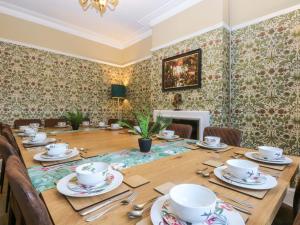 een eetkamer met een houten tafel met stoelen bij Southbourne Manor in Llandudno +35 foto's