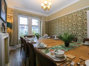een eetkamer met een lange tafel en stoelen bij Southbourne Manor in Llandudno