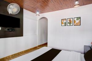 una camera da letto con un letto e una TV a schermo piatto di Super Collection O Police Bazar Shillong Formerly Pillars House a Shillong