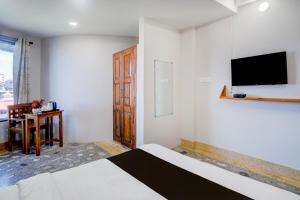 una camera da letto con un letto e una TV a parete di Super Collection O Police Bazar Shillong Formerly Pillars House a Shillong Altre 24 foto