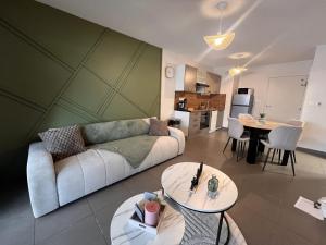 een woonkamer met een bank en een tafel bij Appartement Standing 5mn Village de Noël in Le Barcarès