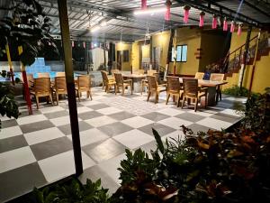 a patio with tables and chairs on a checkered floor at Deepdaya Cottage in Alibag