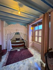 a bedroom with a canopy bed and a window at Suite Dôme Jasmin in Bin Rhilouf