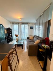 una sala de estar con un sofá y una mesa en L'Ouvrage - Grand Studio - La Rochelle, en La Rochelle