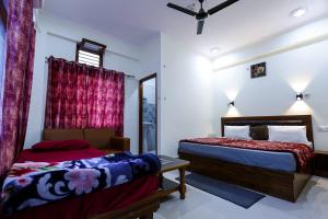 a bedroom with two beds and a window at Hotel Saurabh in Saur