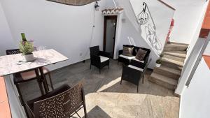 a room with a table and chairs and stairs at La posada del Cani in Cómpeta