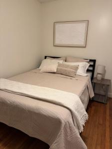 a bed in a bedroom with a picture on the wall at Bright 2BR and1BA Home Near Old Town, Metro, Airport and Potomac Yard in Alexandria