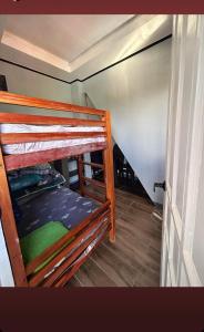莫阿尔博阿Tiny House in Moalboal Saavedra的带两张双层床和楼梯的客房