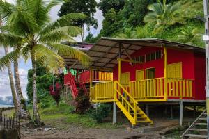 a red and yellow house with a yellow staircase at Posadas Jamaica in Bahía Solano