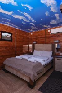 a bedroom with a large bed with a blue ceiling at Cuki Residence in Mala Ravna Reka