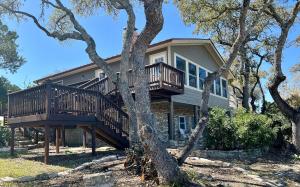 ein Haus mit einer Terrasse inmitten von Bäumen in der Unterkunft Canyon Lake House with Lake View in Canyon Lake