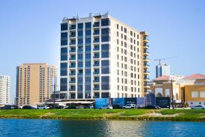 a tall white building next to a body of water at Chicago Apartment in Al Khobar