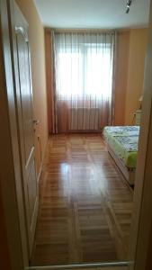 a small room with a bed and a window at Daria Apartment in Novi Sad