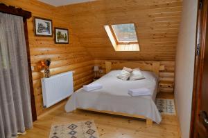 ein Schlafzimmer mit einem Bett in einer Blockhütte in der Unterkunft Флояра in Kozmacz