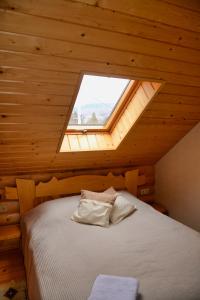 ein Bett in einem Holzzimmer mit Fenster in der Unterkunft Флояра in Kozmacz