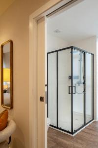 a glass shower door in a bathroom with a toilet at Foz Apartments & Suites in Figueira da Foz +60 photos