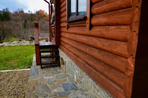 eine Seite einer Blockhütte mit einem Fenster in der Unterkunft Флояра in Kozmacz
