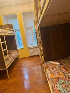 Una habitación con dos literas y suelo de madera. en Hostello, en Baku