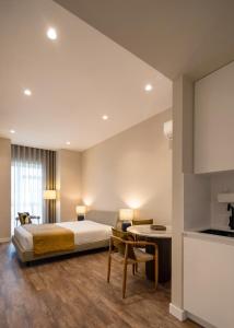ein Hotelzimmer mit Bett und Schreibtisch in der Unterkunft Foz Apartments in Figueira da Foz + 60 Fotos