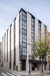 ein großes Gebäude mit schwarzen Fenstern auf einer Straße in der Unterkunft Foz Apartments in Figueira da Foz