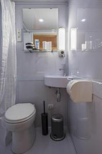 ein weißes Badezimmer mit Toilette und Waschbecken in der Unterkunft Studio long term stay in Makkum in Makkum