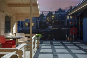 eine Terrasse mit Tisch und Stühlen auf einem Balkon in der Unterkunft Studio long term stay in Makkum in Makkum