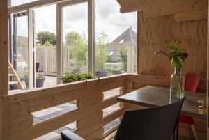 a dining room with a table and a large window at Studio long term stay in Makkum in Makkum