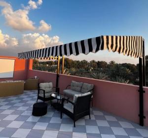 a patio with chairs and an umbrella on a roof at The Pink Pool - Swimming pool in Ras al Khaimah