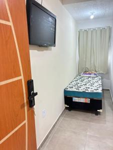 Kleines Zimmer mit einem kleinen Bett und einem Flachbild-TV. in der Unterkunft Pousada sussego in Prado