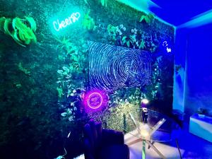 ein Tisch mit einer violetten Lampe an der Wand in der Unterkunft Milano Bicocca Apartment & Rooms in Cinisello Balsamo