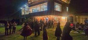 a group of people standing outside of a building at night at Cuscungo Cotopaxi Hostel & Lodge in Chasqui
