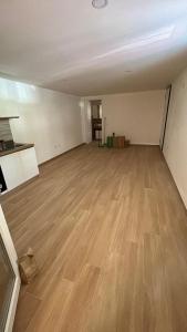 伊格莱西亚斯Il Granchio Blu的一间空房间,铺有木地板,设有一间厨房