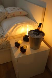 a bottle of wine in a bucket on a table next to a bed at Apartament Nowa in Jarocin +13 photos