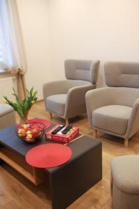 a living room with chairs and a table with a bowl of fruit at Apartament Nowa in Jarocin