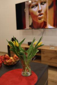 a vase with yellow flowers in it on a table at Apartament Nowa in Jarocin