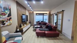 a living room with a couch and a tv at Baltic Infinity Apartments in Międzyzdroje