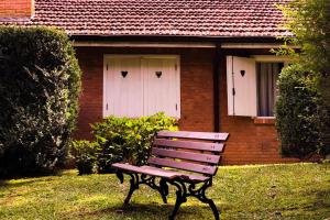 a bench in front of a house with two white doors at Reserva da Raposa in Monte Verde +171 photos