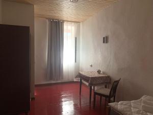 ein Raum mit einem Tisch und Stühlen und einem Fenster in der Unterkunft Guesthouse Lantia in Mestia