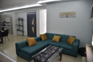 un soggiorno con un divano verde e un tavolo di Cactus luxury apartment oreoi a Oreoi