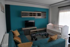 un soggiorno blu con un divano e una culla di Cactus luxury apartment oreoi a Oreoi