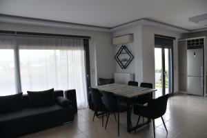 una sala da pranzo con tavolo, sedie e divano di Cactus luxury apartment oreoi a Oreoi