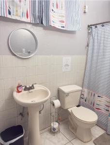 a bathroom with a sink and a toilet and a mirror at Cabanas Playa Santa/ Apto. A/ Swimming Pool/ Pool Table/ WIFI/ 3 min Beaches in Guanica