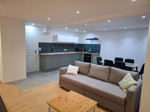 een woonkamer met een bank en een keuken bij Maison Fantastique in Jargeau