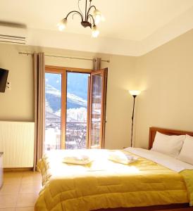 Un dormitorio con una cama y una ventana grande. en Guesthouse Lithos, en Kalambaka