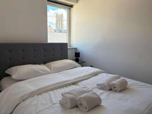 a bedroom with two towels on a bed with a window at York City Centre 2 Bed Flat with Views - Steps from Christmas Market in York