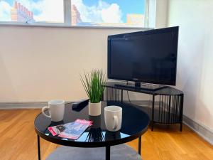 a living room with a tv and a coffee table at York City Centre 2 Bed Flat with Views - Steps from Christmas Market in York