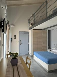1 dormitorio con 1 cama y 1 mesa con 1 cama azul en Zathea Apartments, en Agia Pelagia - Citera